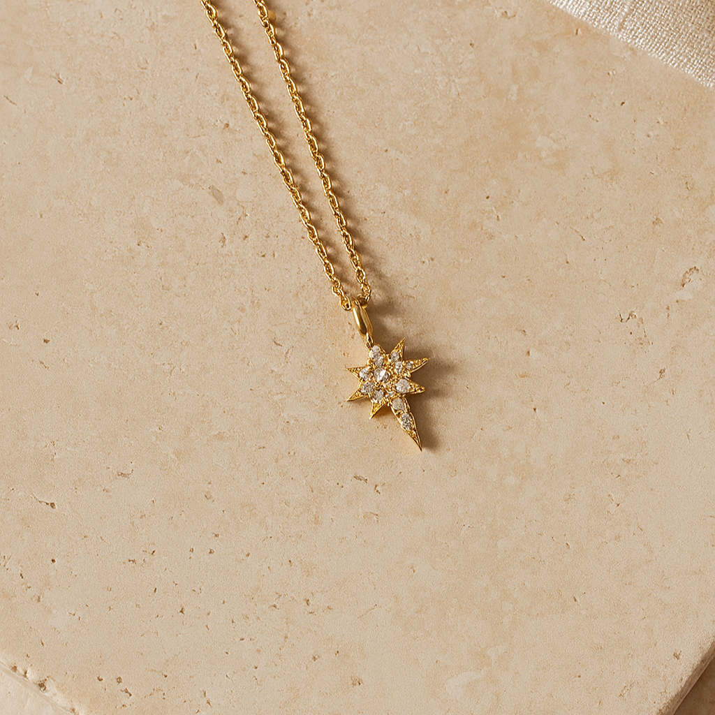 Gold necklace with a star-shaped pendant on a beige background